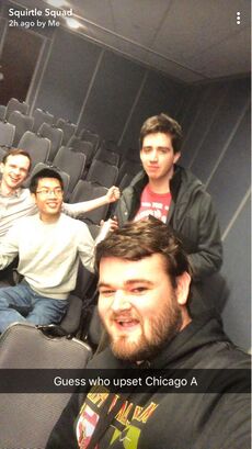 Screenshot of a message in the Snapchat group "Squirtle Squad" showing three people in celebratory poses in a conference room while in front an excited man holds a front-facing camera with the caption "Guess who upset Chicago A" overlaid on the image.